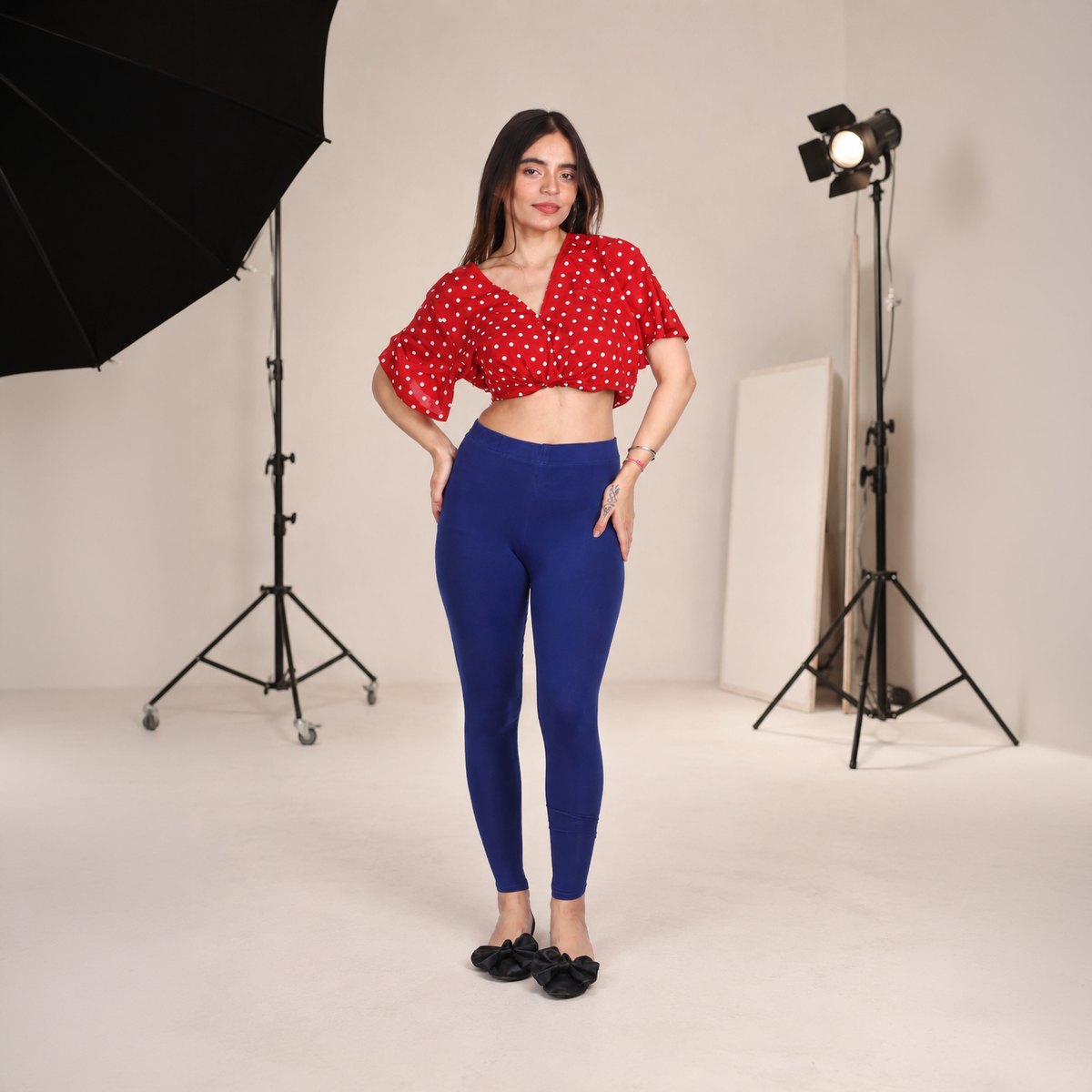 Studio fashion model wearing red top and blue leggings